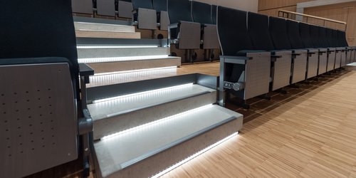 Sicherheit auf der Treppe Die Treppe zur ansteigenden Bestuhlung des Veranstaltungsraums ist beleuchtet.